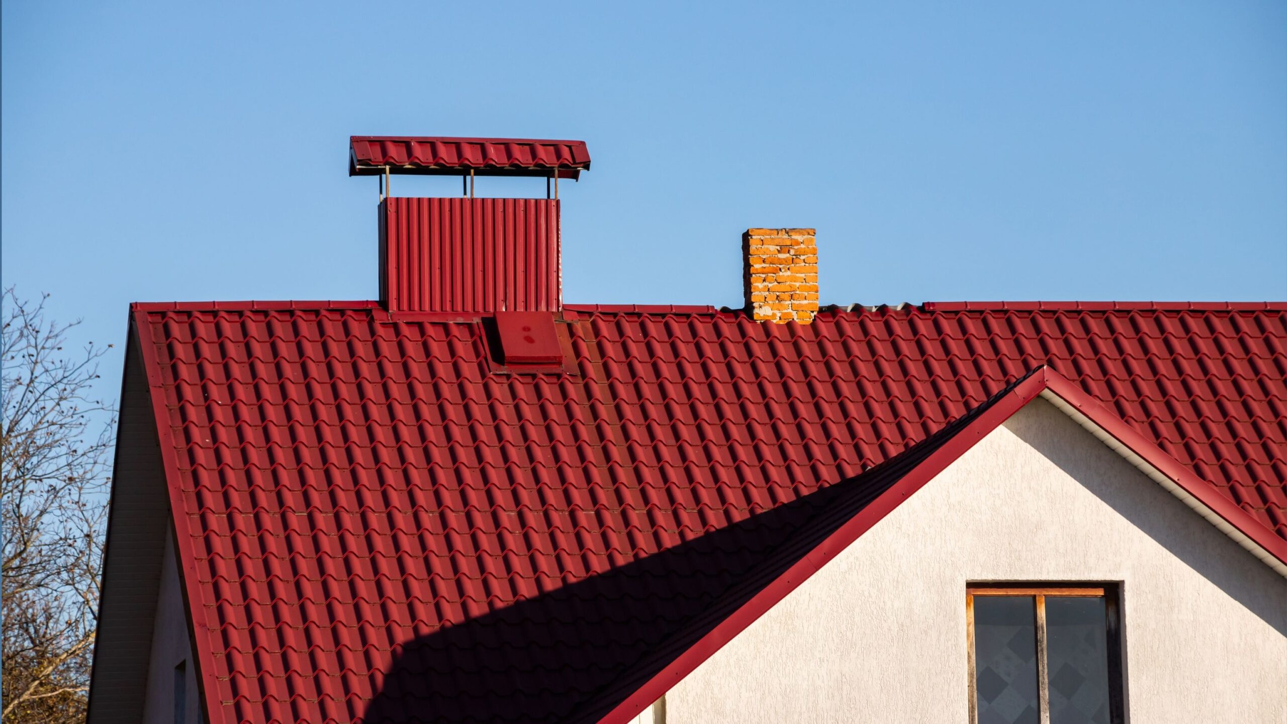 Red metal roof with small brick chimney